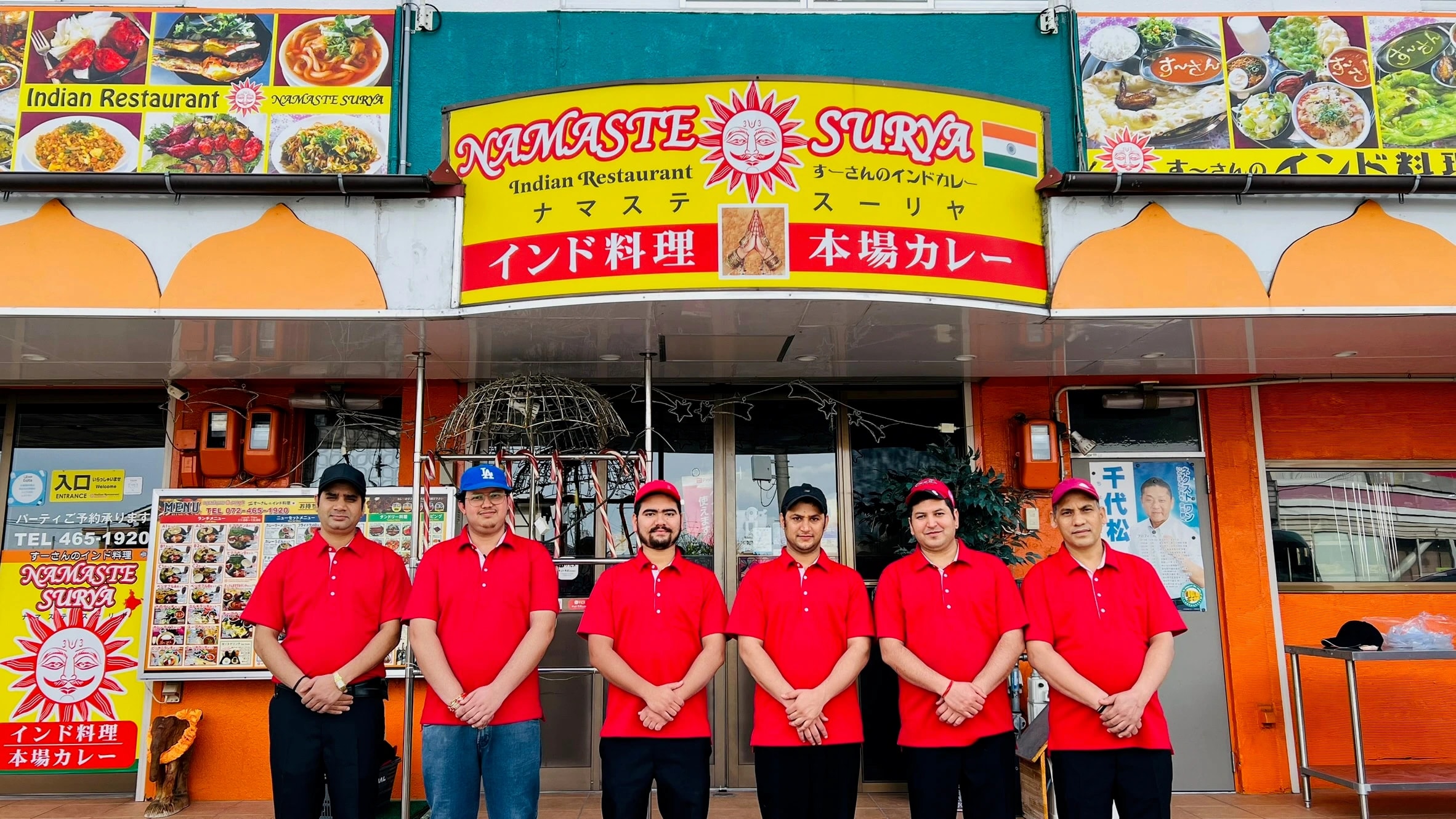 The Namaste Surya team in red shirts outside the restaurant, beneath its sign