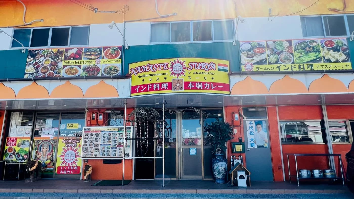 オレンジ色の外観と看板が目印のナマステスーリヤの店舗
